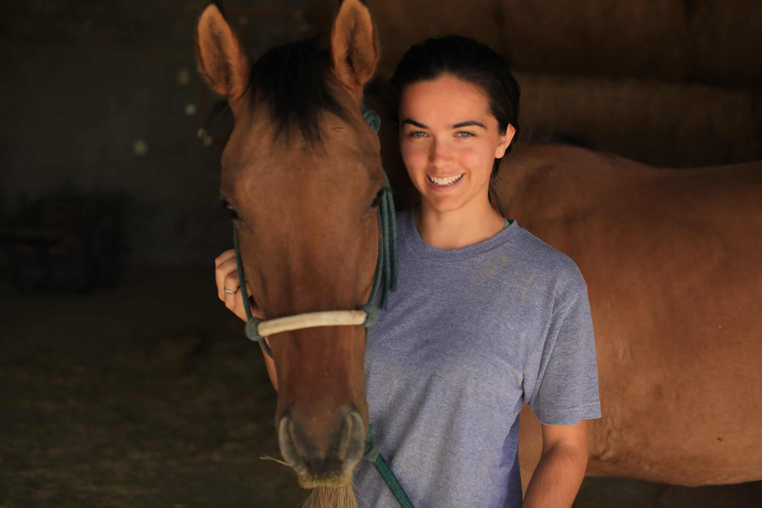 This is me posing with my buckskin mustang rescue horse, Ivan. Ivan is not even two yet, but his easygoing personality has taken every training challenge I've thrown at him so far. He's also a cute charmer, a very social horse that loves attention and has no idea of personal space.