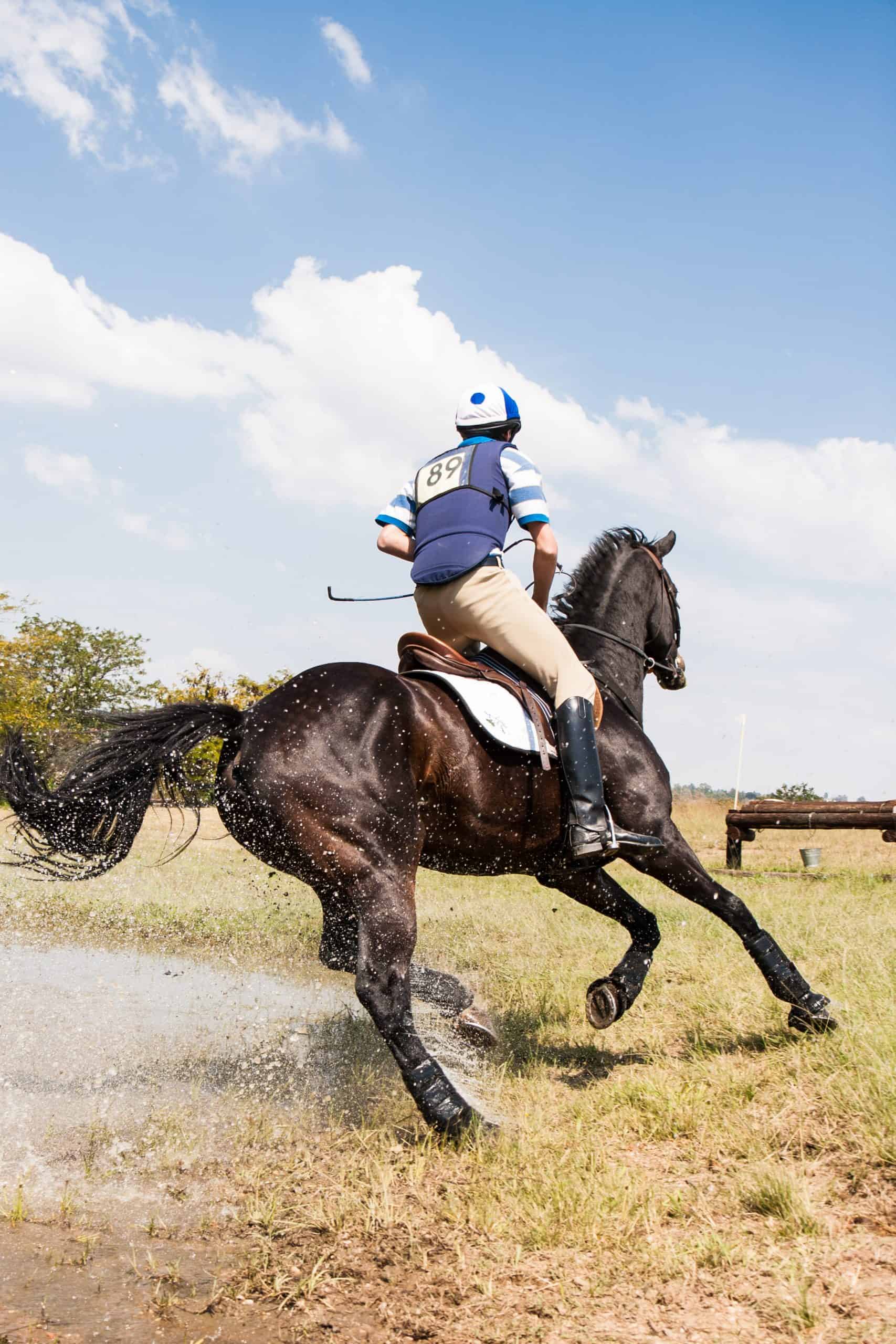 Horse and rider cornering at speed, after successfully negotiating a water jump – Inanda Country Club, Johannesburg, South Africa.