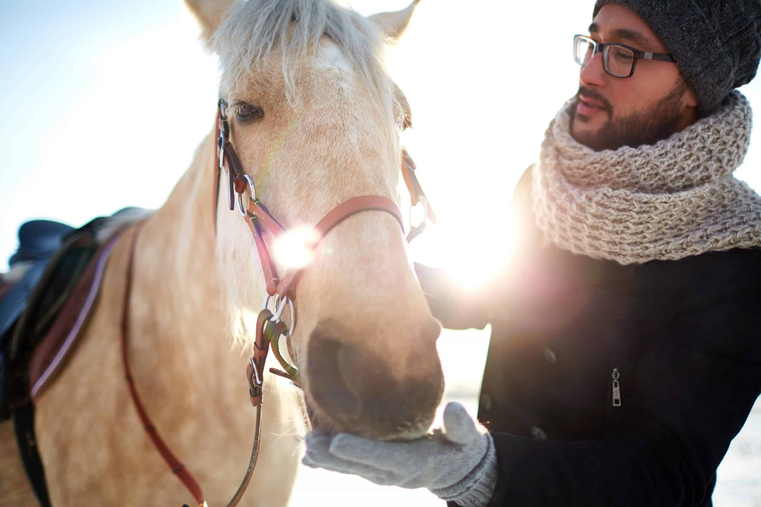 Young man in winterwear and his horse