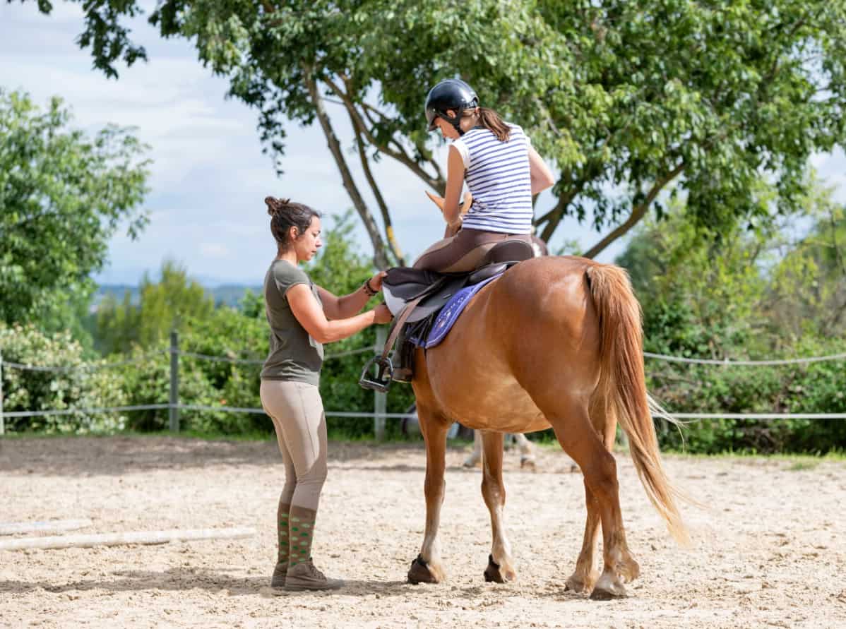 Horse instructor teaching children.