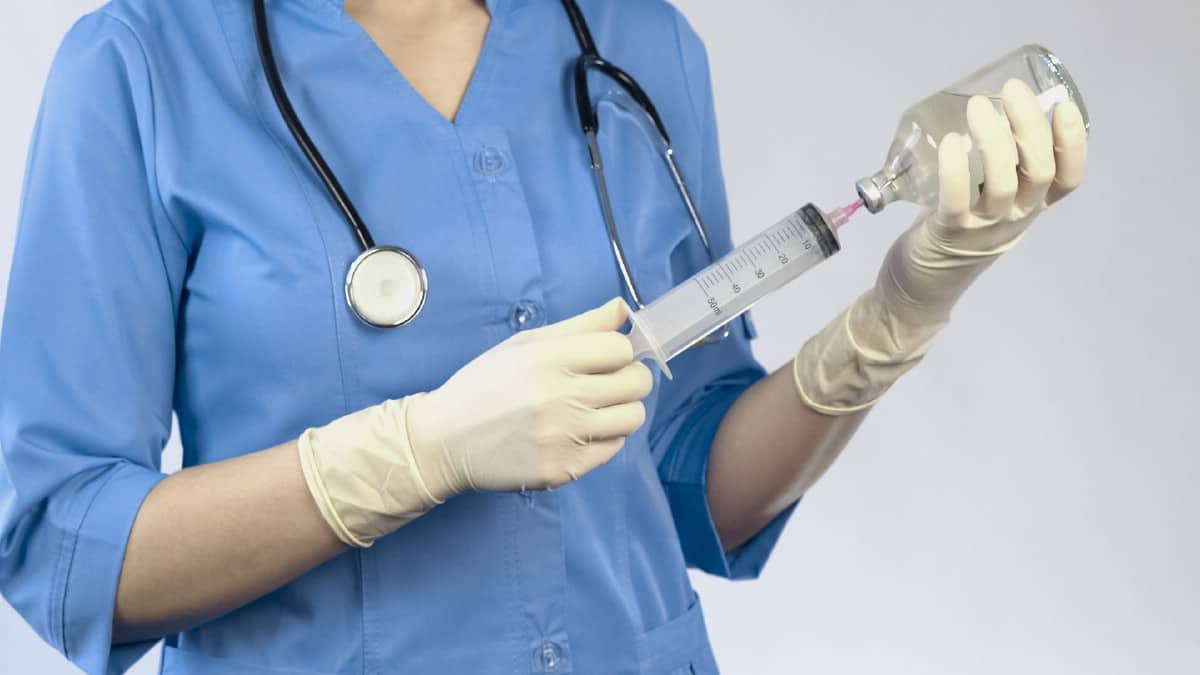 Vet preparing syringe.