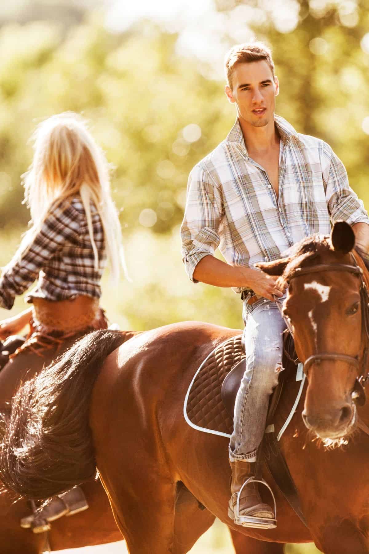 Couple on brown horses with glowing sunlight background