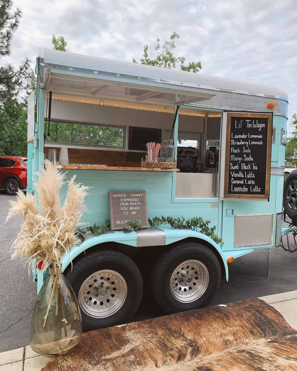 A ligh-blue horse trailer rebuilded as a small bar.