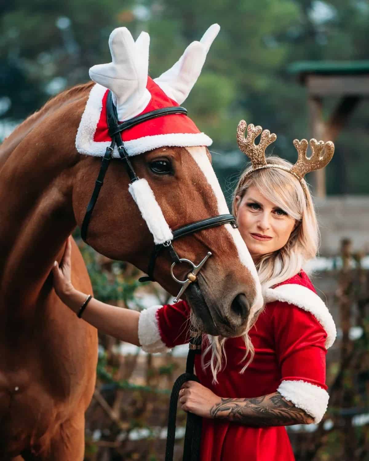 A young woman and a brown horse wearing matching outfits.