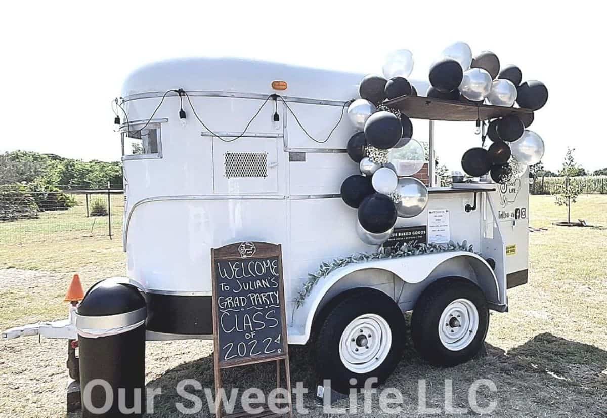 A white horse trailer decorated with balloons rebuilded as a smal lbar.