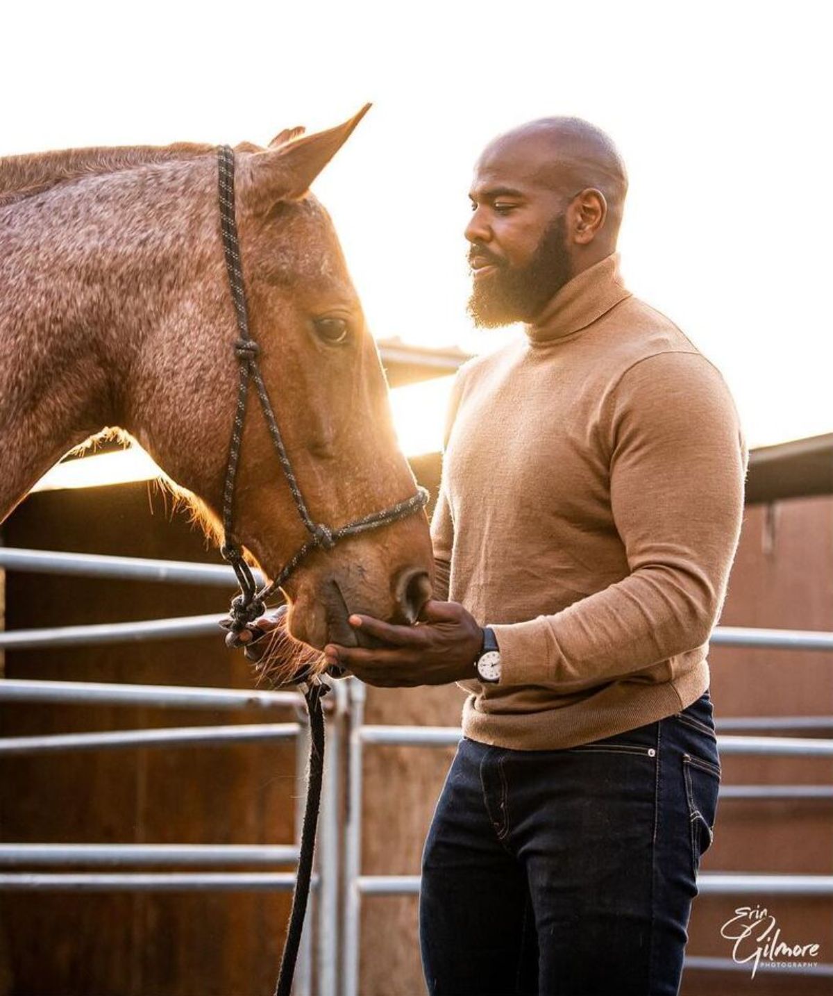 A man pets his brown horse.