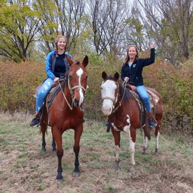 Two young women enjoying a horseback ride.