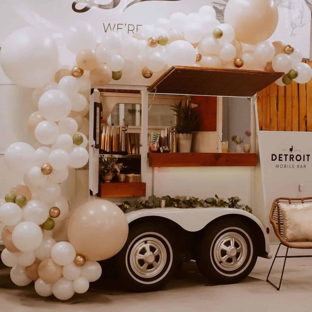A horse trailer decorated with balloons rebuilded as a small bar.