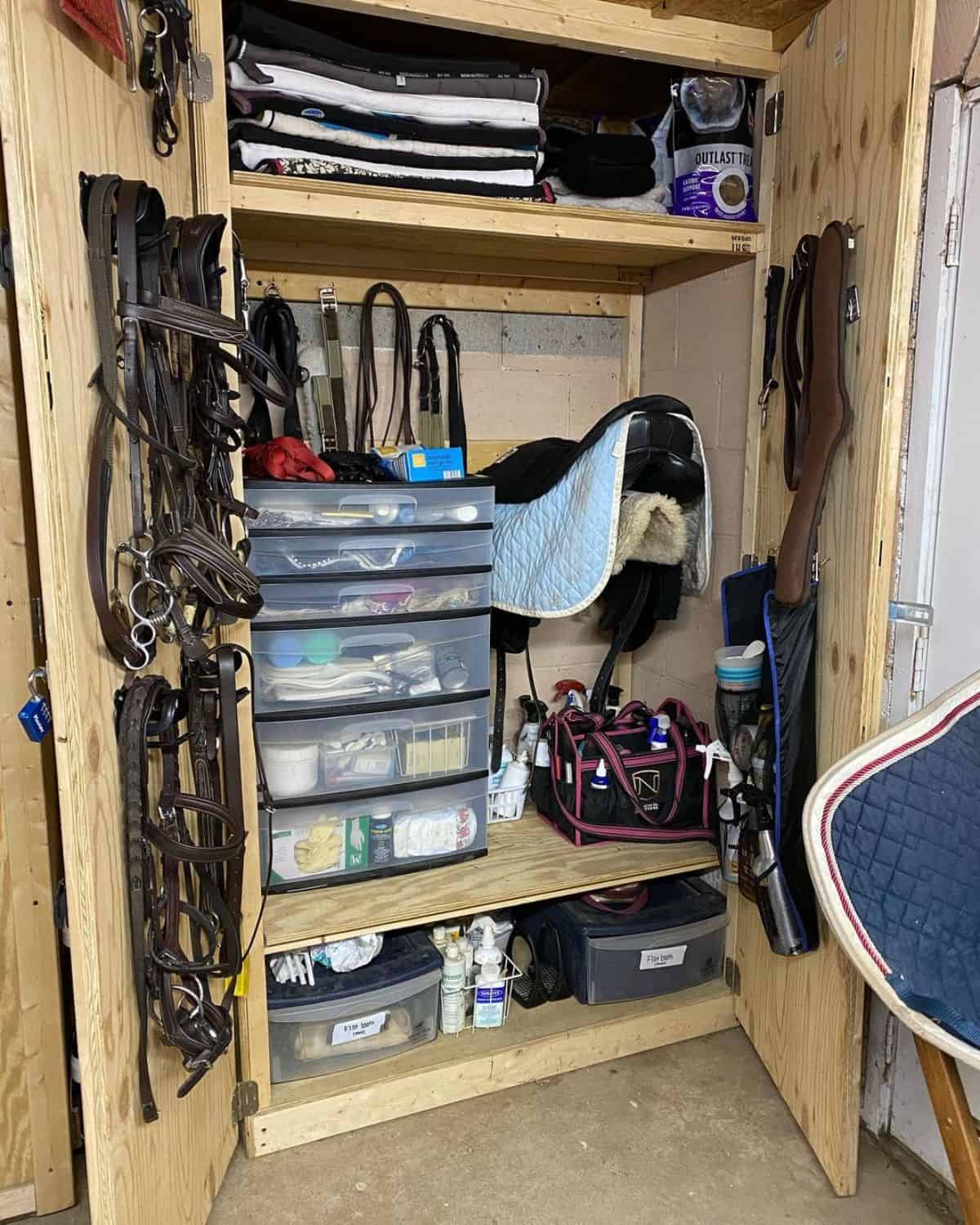 A tack cabinet filled with all kinds of horse accessories.