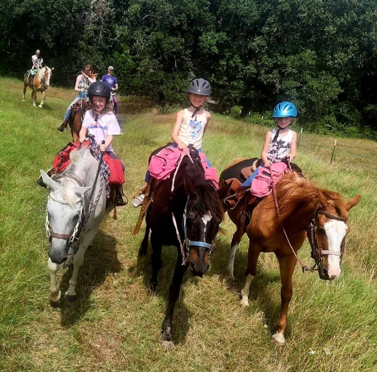 A group of people enjoying a horseback ride.