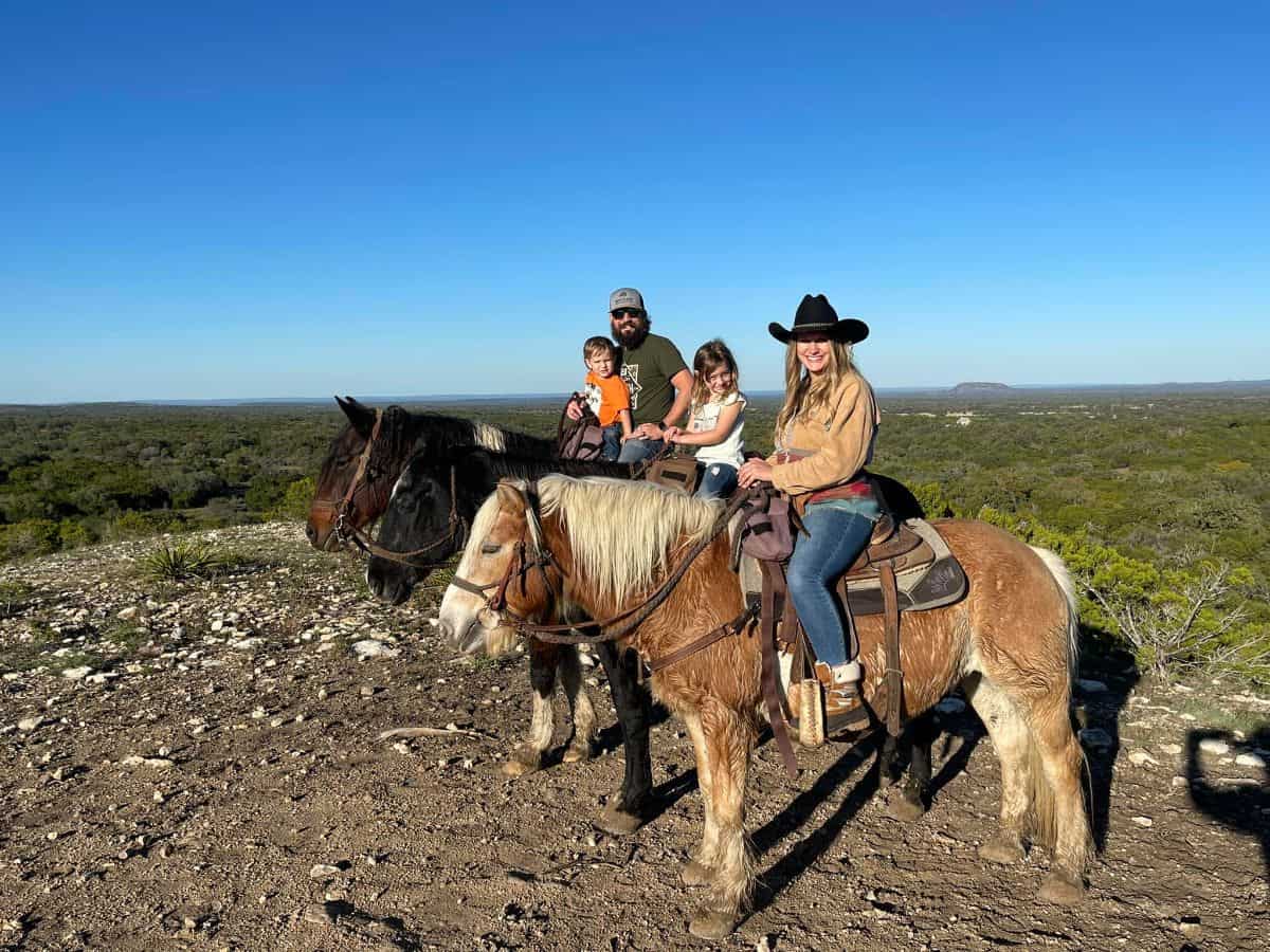 A young family enjoy a horseback ride.