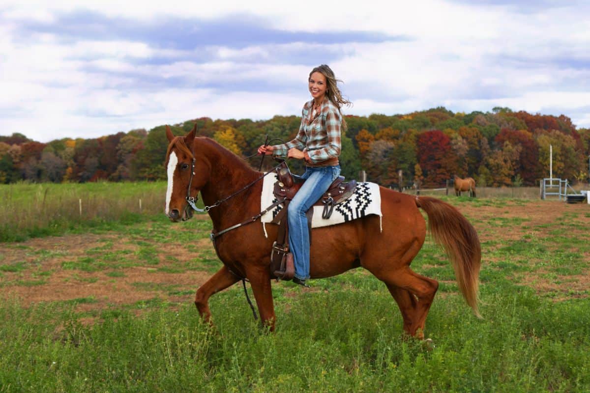 A young woman enjoying a horseback ride.