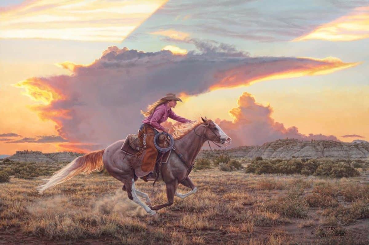 A cowboy rides a brown American Quarter Horse on a field.