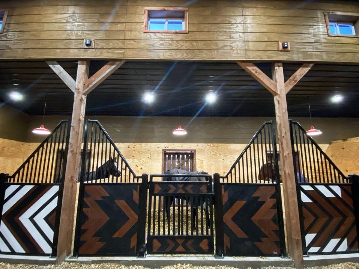 A wooden horse barn with a tribal design.