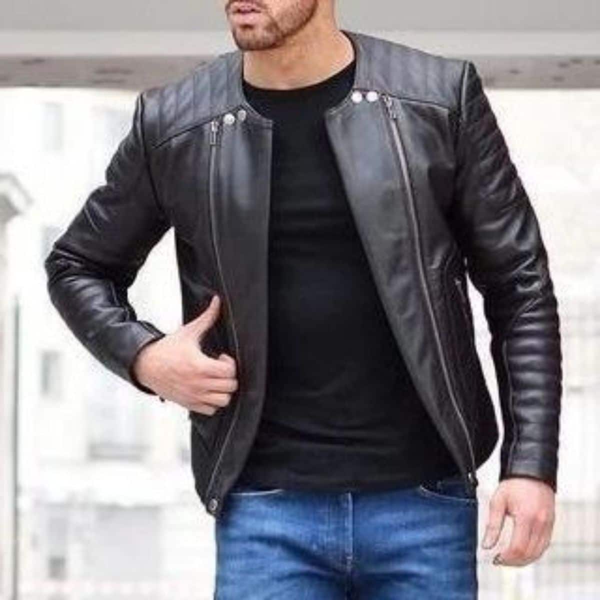 A man wears a leather jacket and a blue jeans.