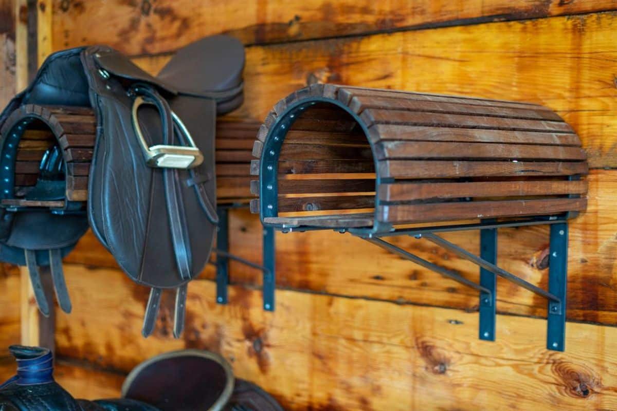 Two saddle racsk in a barn.