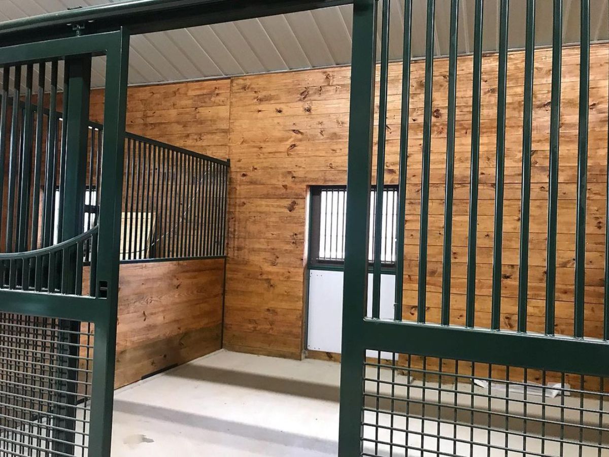 A basic horse stall with a wooden interior.