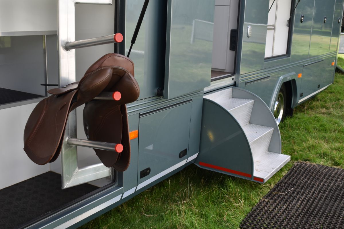 Saddle rack with a leather saddle on a trailer.