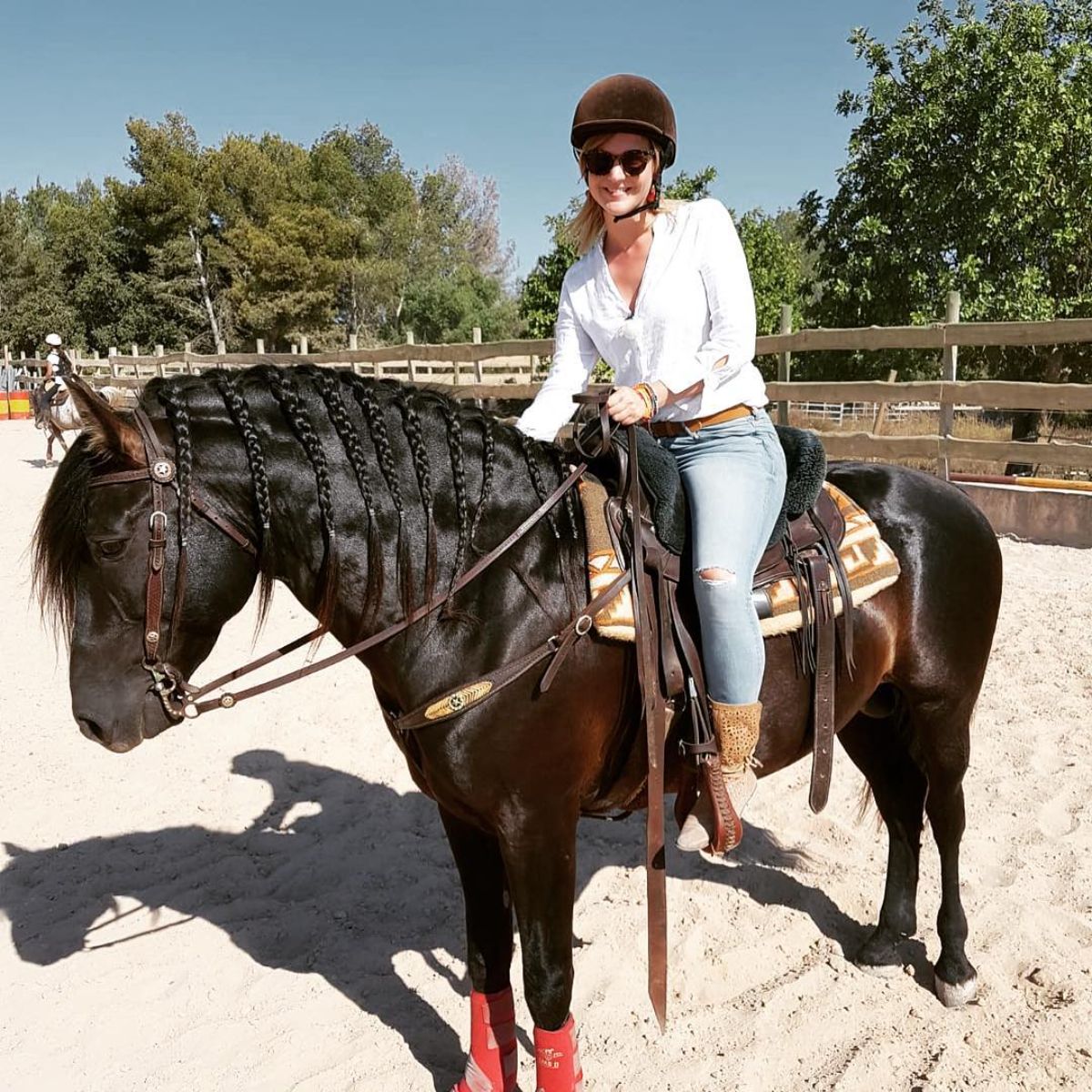 A woman sits on a brown Mallorquin horse.